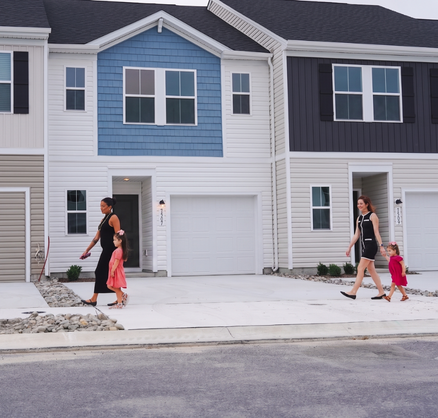 People walking in front of townhomes People walking in front of townhomes